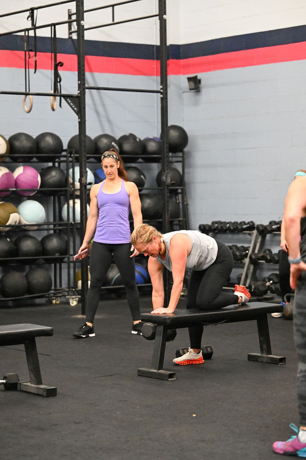 Personal trainer coaching dumbbell exercise at Monument Fitness gym in Charlestown